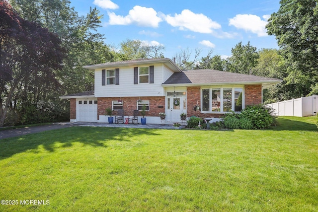 67 Koenig Ln, Freehold, NJ 07728 - tri-level home featuring brick siding, asphalt driveway, and a garage