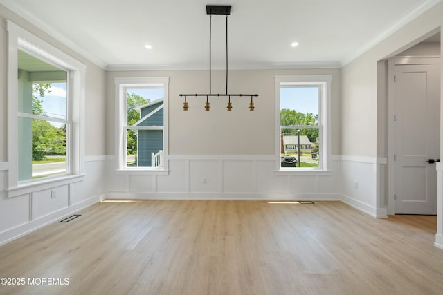 783 Delaware Ave, Manahawkin, NJ 08050 - unfurnished dining area featuring crown molding, light wood-style floors, wainscoting, and a decorative wall