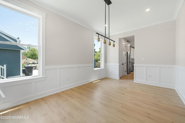 783 Delaware Ave, Manahawkin, NJ 08050 - unfurnished dining area featuring healthy amount of natural light, wainscoting, light wood-style flooring, crown molding, and a decorative wall