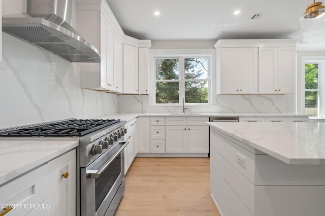 783 Delaware Ave, Manahawkin, NJ 08050 - kitchen with high end stainless steel range, wall chimney range hood, a sink, recessed lighting, and white cabinets