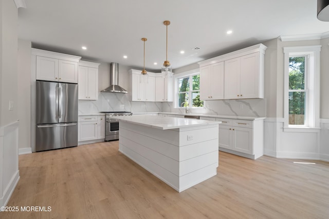 783 Delaware Ave, Manahawkin, NJ 08050 - kitchen featuring appliances with stainless steel finishes, wall chimney range hood, light wood-style flooring, white cabinetry, and recessed lighting