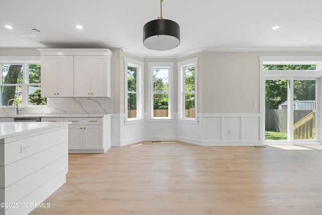 783 Delaware Ave, Manahawkin, NJ 08050 - kitchen with light countertops, white cabinetry, recessed lighting, light wood-style flooring, and decorative light fixtures