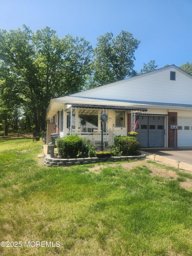 235 Columbine Ave Unit A, Whiting, NJ 08759 - view of front of house with a front lawn, an attached garage, concrete driveway, brick siding, and covered porch