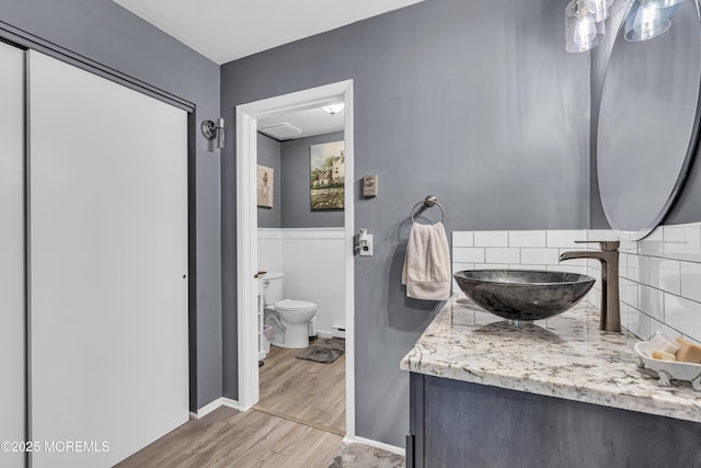 235 Columbine Ave Unit A, Whiting, NJ 08759 - bathroom featuring vanity, wood finished floors, toilet, decorative backsplash, and baseboard heating