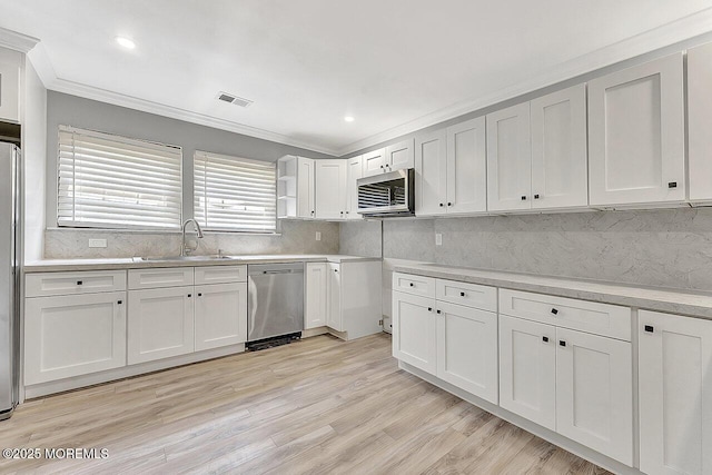 112 Azalea Cir, Jackson, NJ 08527 - kitchen with stainless steel appliances, a sink, crown molding, light wood finished floors, and backsplash