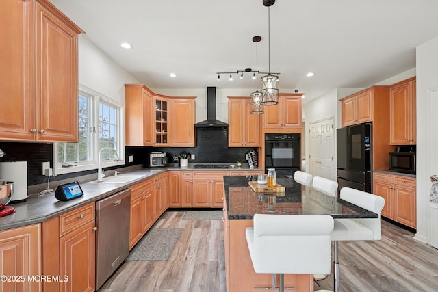 7 Cranberry Ct, Haledon, NJ 07508 - kitchen with black appliances, wall chimney exhaust hood, a kitchen island, light wood finished floors, and a breakfast bar area