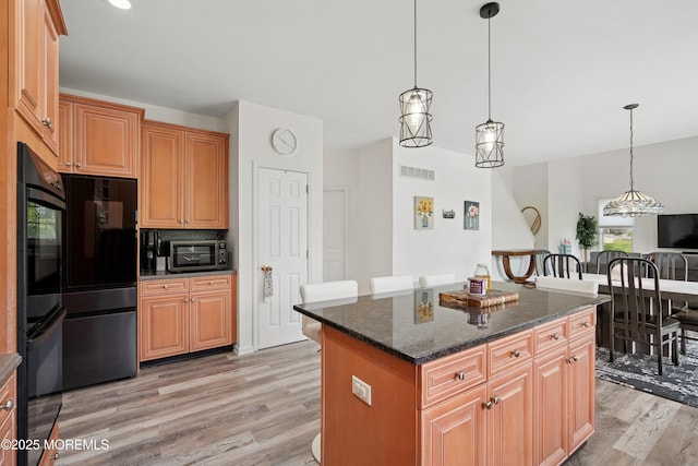 7 Cranberry Ct, Haledon, NJ 07508 - kitchen featuring light wood-style flooring, stainless steel microwave, fridge, a center island, and decorative light fixtures