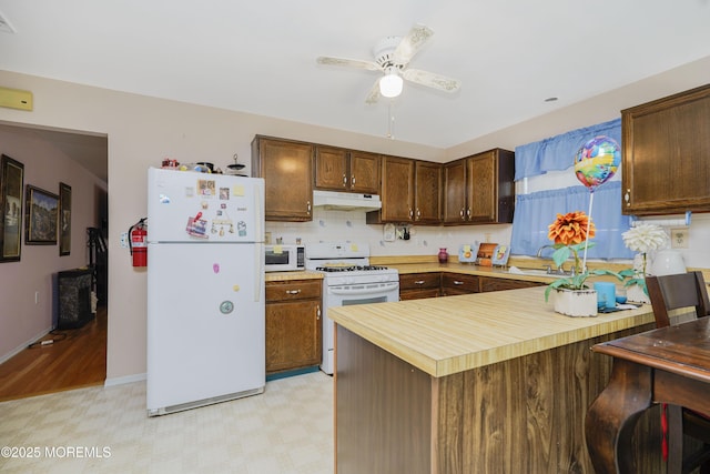 62 Virgin Islands Dr, Toms River, NJ 08757 - kitchen with white appliances, under cabinet range hood, a peninsula, light flooring, and a ceiling fan