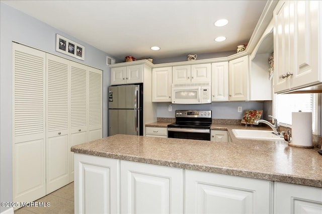 648 Pulham Ct Unit B, Manchester, NJ 08759 - kitchen featuring white microwave, electric stove, freestanding refrigerator, a sink, and a peninsula