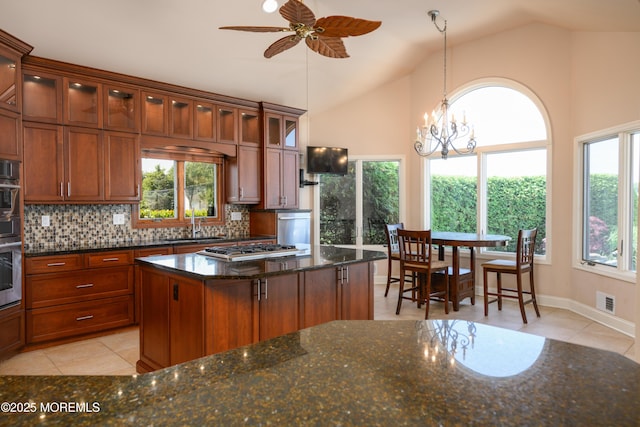 324 Magnolia Ave, Brielle, NJ 08730 - kitchen with light tile patterned flooring, decorative backsplash, dark stone counters, ceiling fan, and hanging light fixtures