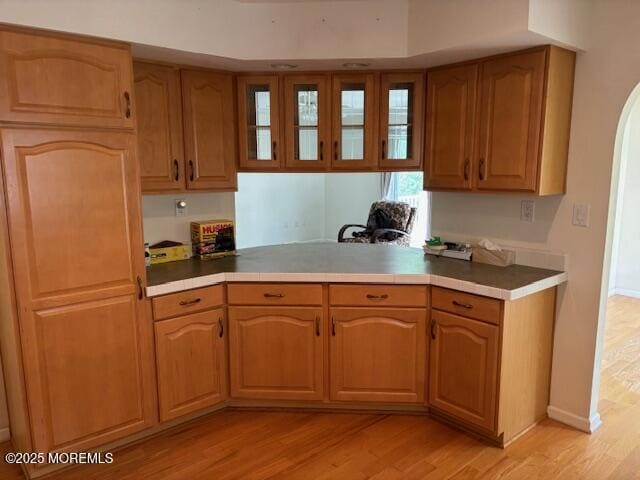 184 Pebble Beach Dr, Mays Landing, NJ 08330 - kitchen featuring light wood finished floors, glass insert cabinets, light countertops, and arched walkways