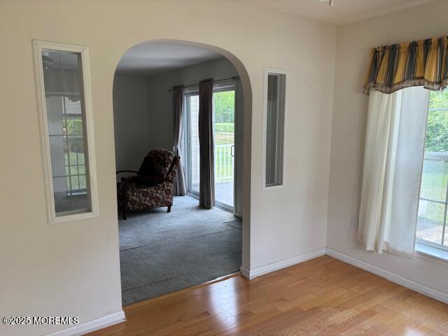 184 Pebble Beach Dr, Mays Landing, NJ 08330 - empty room featuring arched walkways, plenty of natural light, and wood finished floors