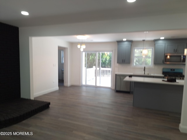 414 Oak Tree Rd, Freehold, NJ 07728 - kitchen with appliances with stainless steel finishes, dark wood-style flooring, light countertops, tasteful backsplash, and pendant lighting