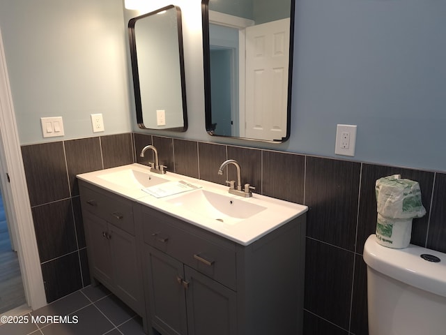 414 Oak Tree Rd, Freehold, NJ 07728 - bathroom featuring a wainscoted wall, double vanity, tile walls, and tile patterned floors