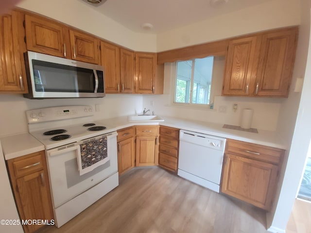 799 Hudson Pkwy, Whiting, NJ 08759 - kitchen featuring white appliances, a sink, light countertops, light wood-style floors, and brown cabinets