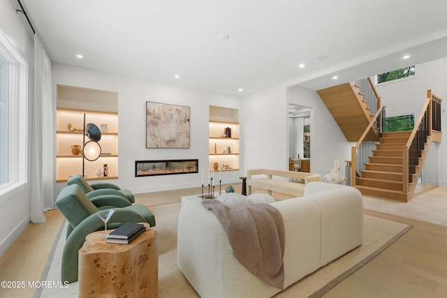 428 Wells Ave, Oakhurst, NJ 07755 - living room featuring stairs, plenty of natural light, a glass covered fireplace, recessed lighting, and wood finished floors