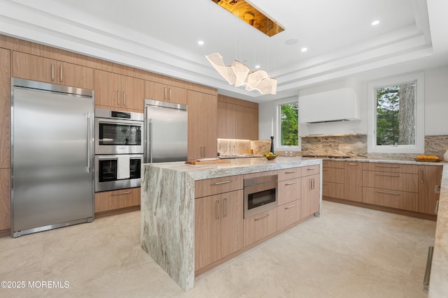 428 Wells Ave, Oakhurst, NJ 07755 - kitchen with appliances with stainless steel finishes, a tray ceiling, a kitchen island, light stone counters, and recessed lighting