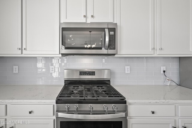 1980 Breakers Dr, Barnegat, NJ 08005 - kitchen with stainless steel appliances, white cabinets, decorative backsplash, and light stone counters