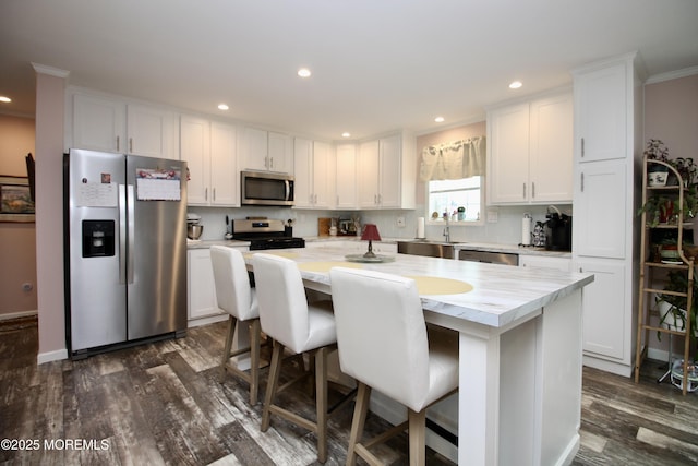 610 Jerome Pl, Freehold, NJ 07728 - kitchen with stainless steel appliances, a kitchen island, white cabinets, light countertops, and dark wood-style floors