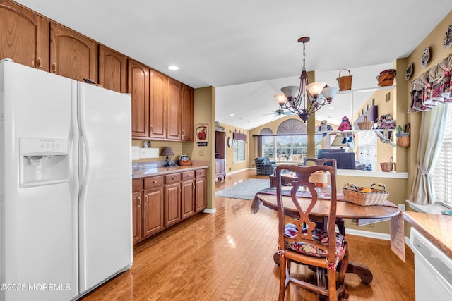 123 Skyline Dr, Lakewood, NJ 08701 - kitchen featuring white appliances, a chandelier, light wood finished floors, brown cabinetry, and vaulted ceiling