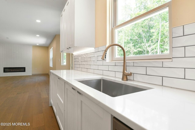 830 Hulses Corner Rd, Howell, NJ 07731 - kitchen featuring wood finished floors, white cabinets, tasteful backsplash, a large fireplace, and recessed lighting