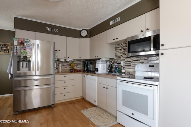 67 Flax Isle Dr, Little Egg Harbor, NJ 08087 - kitchen with appliances with stainless steel finishes, a textured ceiling, tasteful backsplash, a sink, and light wood finished floors