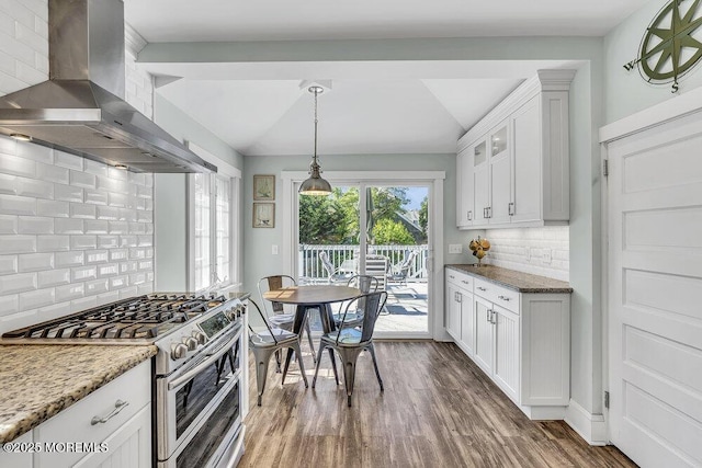 129 Bridge Ave, Bay Head, NJ 08742 - kitchen featuring double oven range, wall chimney exhaust hood, decorative backsplash, white cabinetry, and dark wood-style flooring