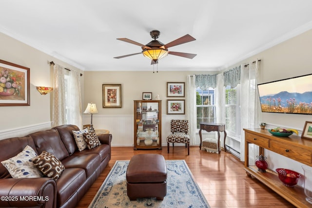 10 Weybridge Pl, Manchester, NJ 08759 - living room featuring a baseboard heating unit, plenty of natural light, wood finished floors, wainscoting, and ornamental molding