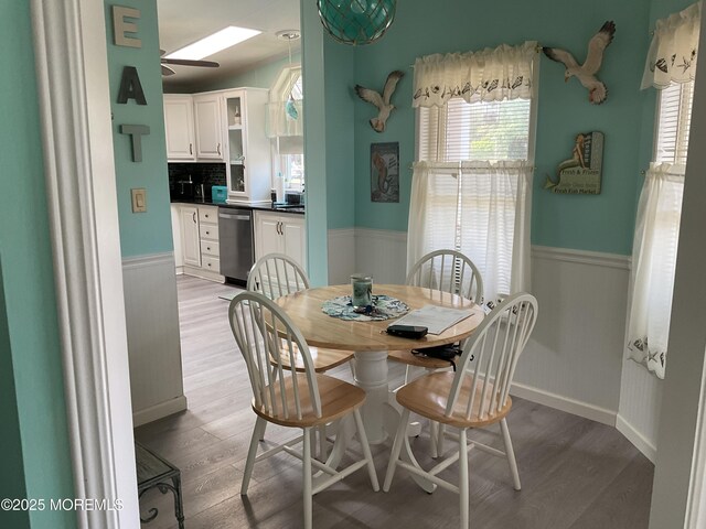 37 Pine Ridge Blvd, Whiting, NJ 08759 - dining space with light wood finished floors, a wainscoted wall, a skylight, ceiling fan, and baseboards