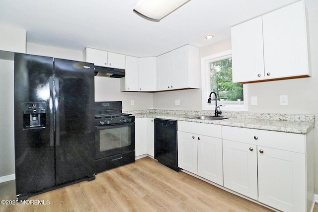 503 Center St, Forked River, NJ 08731 - kitchen with black appliances, a sink, under cabinet range hood, white cabinets, and light wood-style floors