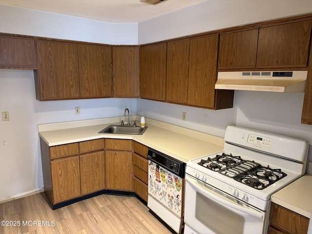 87 Puffin Glade, Berkeley, NJ 08721 - kitchen featuring white gas range oven, dishwashing machine, under cabinet range hood, a sink, and light countertops
