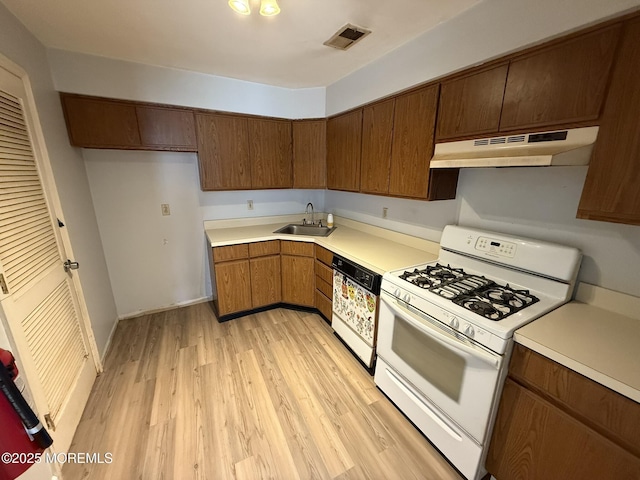 87 Puffin Glade, Berkeley, NJ 08721 - kitchen with white range with gas cooktop, under cabinet range hood, dishwasher, a sink, and light countertops