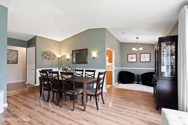 5 E Jack St, Hazlet, NJ 07730 - dining area with a chandelier, vaulted ceiling, light wood-type flooring, baseboards, and a textured ceiling