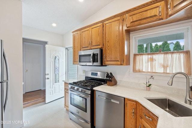 5 E Jack St, Hazlet, NJ 07730 - kitchen with appliances with stainless steel finishes, a sink, vaulted ceiling, light flooring, and brown cabinets