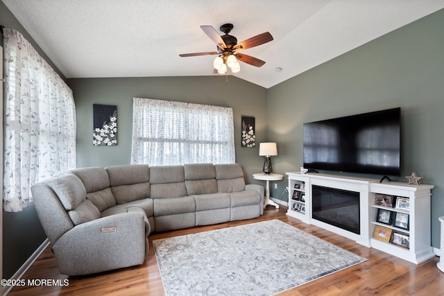 5 E Jack St, Hazlet, NJ 07730 - living area featuring lofted ceiling, a ceiling fan, wood finished floors, a glass covered fireplace, and baseboards