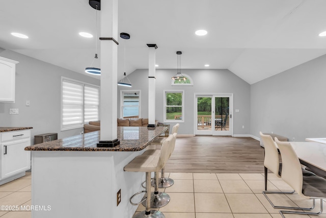 137 Willow Dr, Jackson, NJ 08527 - kitchen with open floor plan, vaulted ceiling, a kitchen breakfast bar, light tile patterned floors, and white cabinets