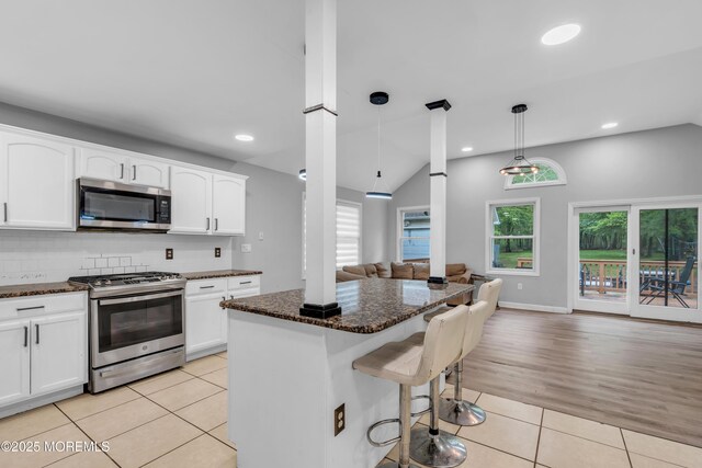 137 Willow Dr, Jackson, NJ 08527 - kitchen with appliances with stainless steel finishes, open floor plan, light tile patterned flooring, a kitchen breakfast bar, and dark stone countertops