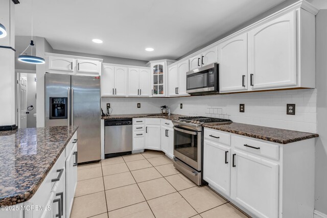 137 Willow Dr, Jackson, NJ 08527 - kitchen with appliances with stainless steel finishes, tasteful backsplash, light tile patterned floors, dark stone countertops, and glass insert cabinets