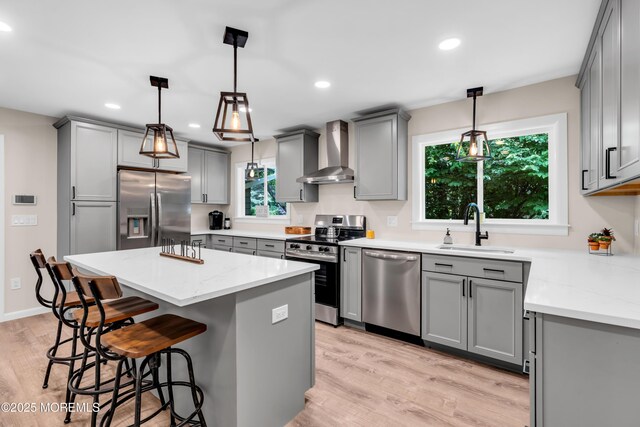 2627 Ramshorn Dr, Manasquan, NJ 08736 - kitchen with appliances with stainless steel finishes, wall chimney range hood, gray cabinetry, a kitchen island, and a breakfast bar area
