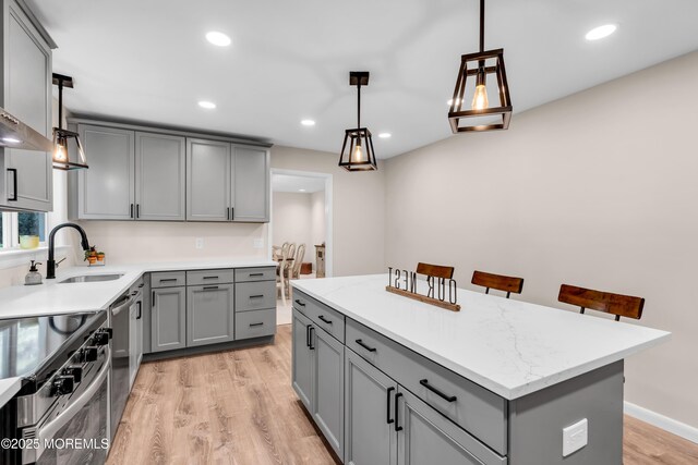 2627 Ramshorn Dr, Manasquan, NJ 08736 - kitchen featuring gray cabinets, stainless steel appliances, light wood finished floors, a center island, and decorative light fixtures