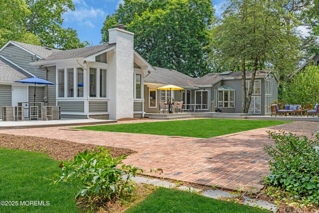 2627 Ramshorn Dr, Manasquan, NJ 08736 - rear view of house featuring a patio, a chimney, and a yard