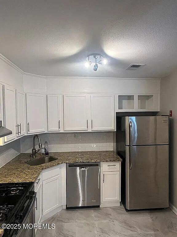 167 Frontier Way, Tinton Falls, NJ 07753 - kitchen featuring stainless steel appliances, a sink, white cabinets, light marble finish floors, and a textured ceiling