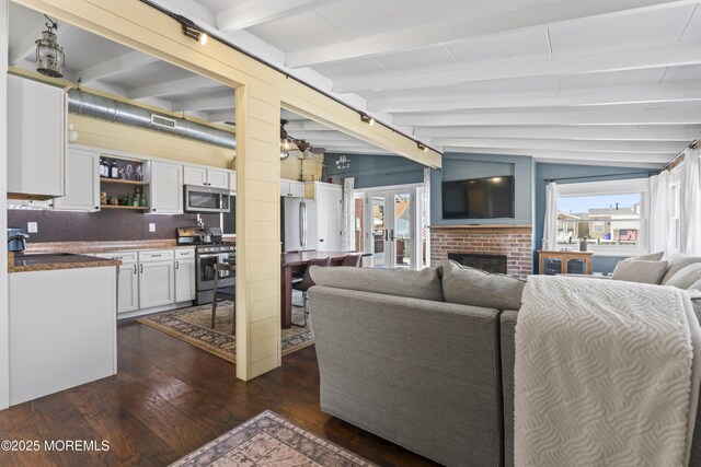 68 Gregg Dr, Beach Haven West, NJ 08050 - living room with dark wood-type flooring, healthy amount of natural light, a brick fireplace, and french doors