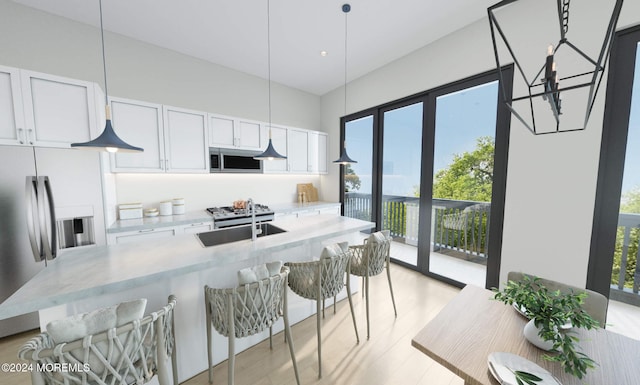 1 5th Ave Unit 409, Neptune City, NJ 07753 - kitchen with stainless steel appliances, a kitchen breakfast bar, a chandelier, white cabinets, and light countertops