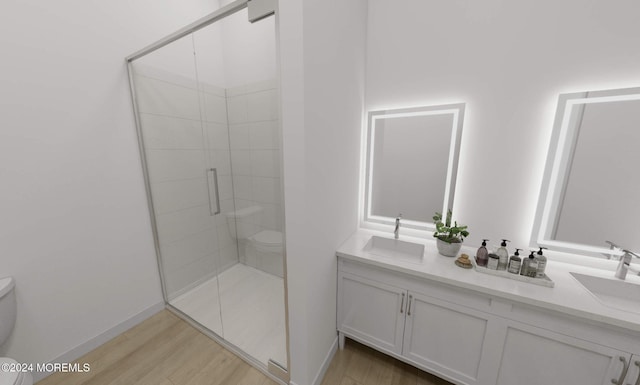 1 5th Ave Unit 409, Neptune City, NJ 07753 - bathroom featuring toilet, double vanity, a shower stall, wood finished floors, and baseboards