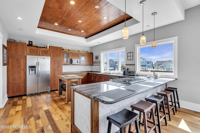 1639 Bay Blvd, Ortley Beach, NJ 08751 - kitchen with stainless steel appliances, a tray ceiling, brown cabinets, a peninsula, and light wood finished floors