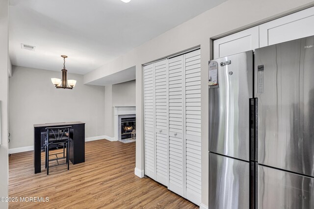 39 Colonial Ct, Jackson, NJ 08527 - kitchen featuring freestanding refrigerator, light wood-style floors, white cabinetry, a chandelier, and baseboards