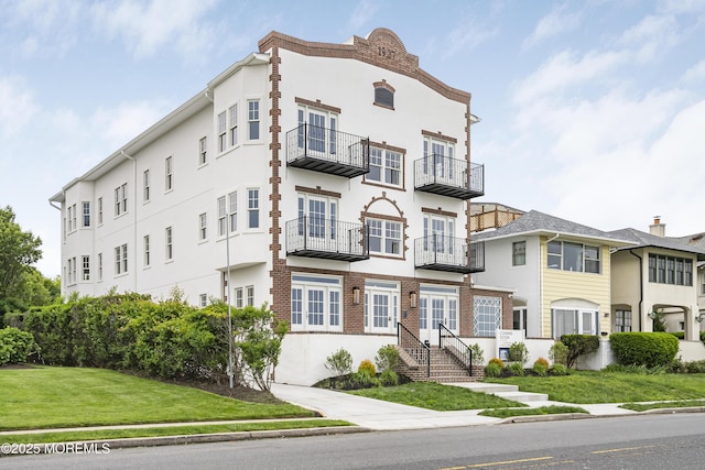 205 Edgemont Dr Unit 2, Loch Arbour Village, NJ 07711 - view of front of house featuring stucco siding and a front lawn