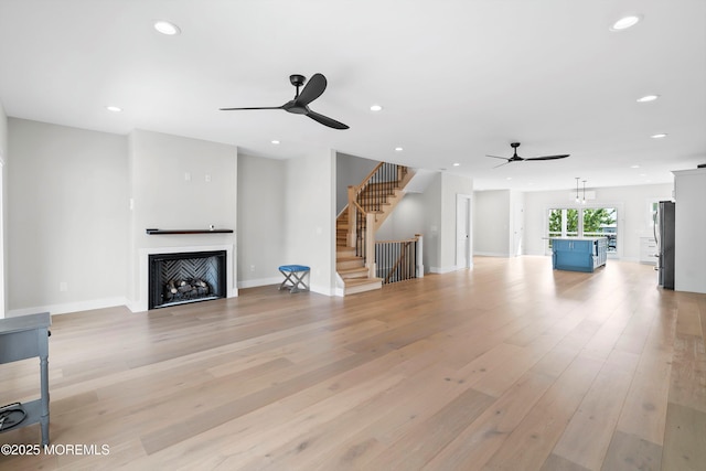 72 4th St, Highlands, NJ 07732 - unfurnished living room with a ceiling fan, a fireplace, recessed lighting, light wood-style floors, and stairway