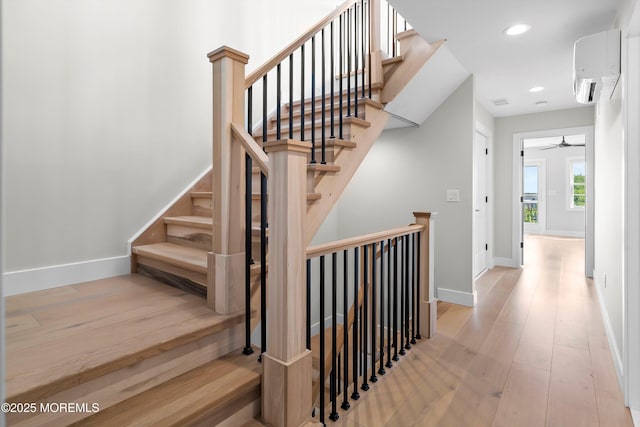 72 4th St, Highlands, NJ 07732 - stairs with wood finished floors, a wall unit AC, recessed lighting, baseboards, and ceiling fan